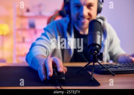 Playing the game. Man in headphones and with microphone is live on the stream. Stock Photo