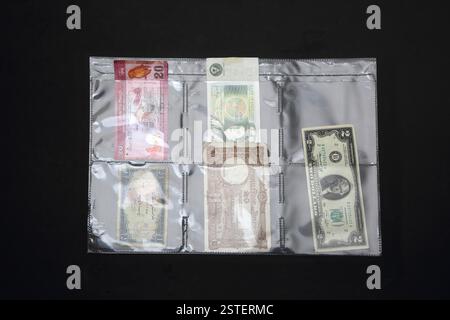 Old Foreign and Sterling Bank Notes in Plastic Hanging Sheet Stock Photo