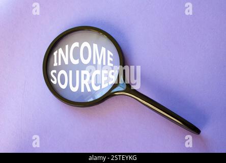 Income Sources symbol. Magnifying Glass with Concept word Income Sources. Beautiful purple background. Business and Income Sources concept. Copy space Stock Photo