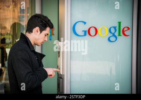 Man ringing the intercom at Google offices Stock Photo