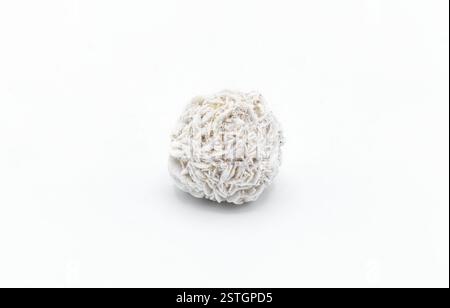 rose like formation of crystal clusters of gypsum mineral. desert rose one single ball isolated on white background. Beautiful flower of nature made o Stock Photo