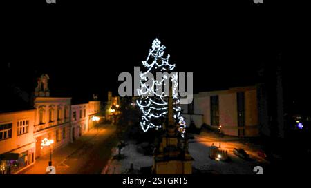 Illuminated Christmas tree. Growing a lighted Christmas tree outside. Blurry view of Christmas tree Stock Photo