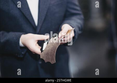 Man holding and examining leather material samples Stock Photo