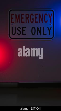 Red and blue light shining on an emergency exit sign Stock Photo