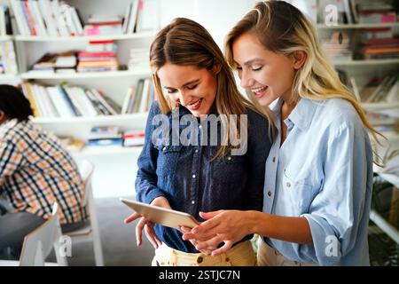 Two young businesspeople using a digital tablet while standing in a boardroom. Stock Photo