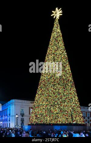 The lavishly decorated Christmas tree in Puerta del Sol located in the centre of Madrid. The gold tree has red baubles and topped with a gold star. Stock Photo