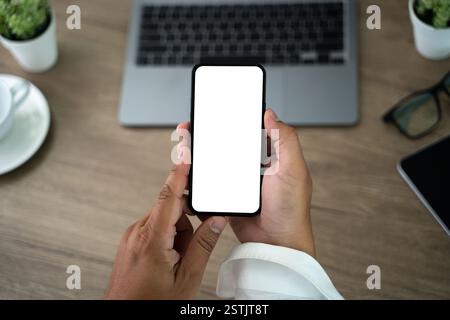 Top view Mockup image hand using a smartphone man Holding Cell Phone With Blank Screen Stock Photo