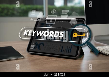 keywords on laptop browse in office optimize seo engine man is using a tablet to type the word "keywords" Stock Photo
