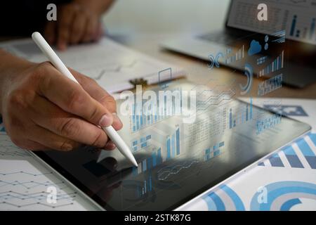 businessman write Statistics Data on a tablet, which is displaying a graph analyzing sales data and financial growth graph chart report Stock Photo