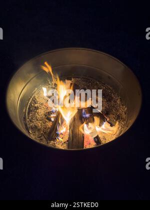High angle view of campfire in metal fire pit at night Stock Photo