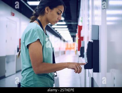 Woman using digital fingerprint scanner in office in server room Stock Photo