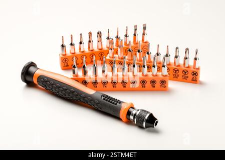 Set of magnetic precision screwdriver bits with black and orange handle on white background Stock Photo