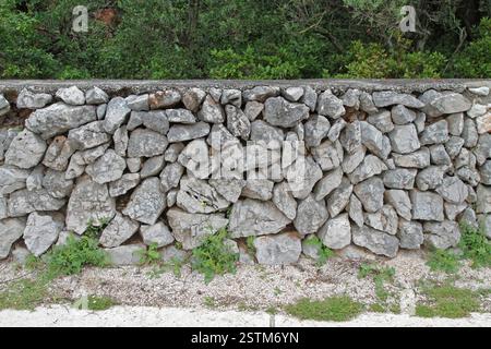 Old dry grey stone rough wall fence Stock Photo