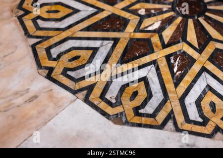 A detailed view of an ornate geometric design made from marble inlays, showcasing bold yellow and white patterns on a smooth surface, perfect for arti Stock Photo