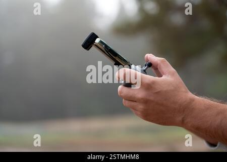 Remote control quadrocopter, close-up. Transmitter for controlling moving device in male hands, blurred nature background. Electronics, hobby, aeromod Stock Photo