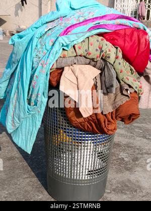 A laundry basket is a lightweight container used for carrying, sorting, and storing clothes before and after washing. Stock Photo