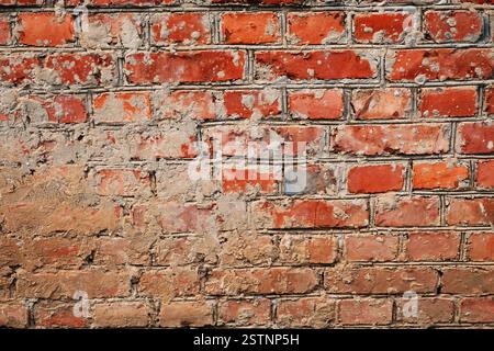 Weathered Stained Old Brick Wall half plastered Stock Photo