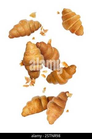 Delicious croissants and crumbs in air on white background. Puff pastry Stock Photo
