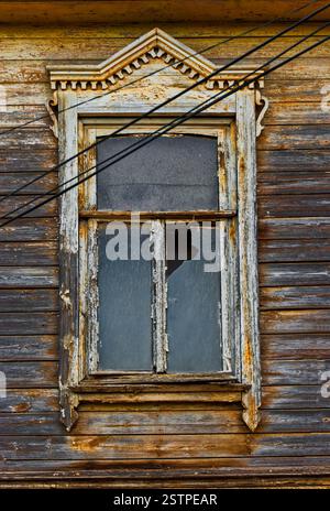 Weathered wooden window in slums with broken glass Stock Photo