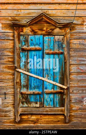 Weathered wooden window in slums painted in peeling blue Stock Photo