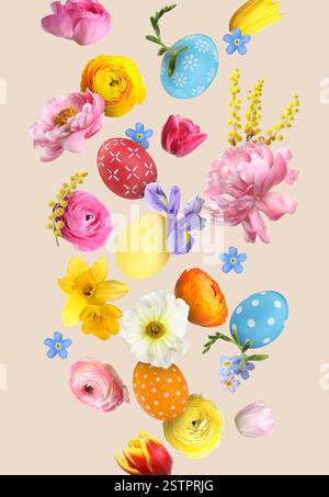 Easter eggs and beautiful spring flowers flying on beige background Stock Photo