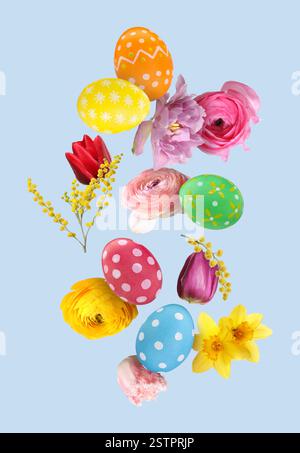 Easter eggs and beautiful spring flowers flying on pastel blue background Stock Photo
