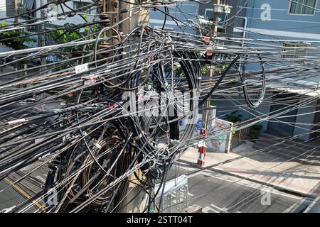 Bangkok, Thailand, January 29th, 2025, Landscape format photograph showing a tangled mess of electrical cables on a post in the city Stock Photo