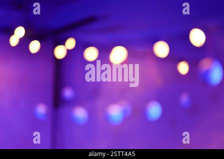 A vibrant display of blurred golden lights creates a warm, enchanting bokeh effect, set against a rich purple background for a dreamy ambiance. Stock Photo