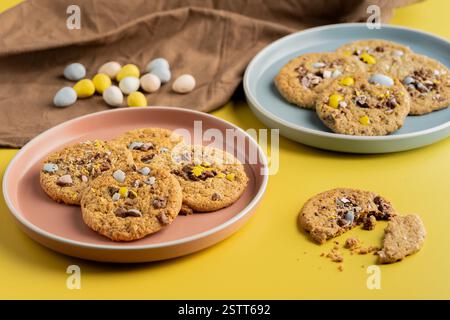 Easter Candy Egg Cookies on Colorful Plates with Yellow Background Stock Photo