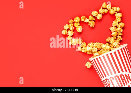 Heart made of popcorn on red background. Valentine's Day celebration Stock Photo