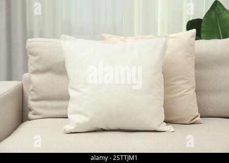 Blank soft pillow on cozy couch indoors Stock Photo