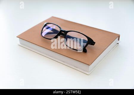 Reading glasses with books on the white table Stock Photo