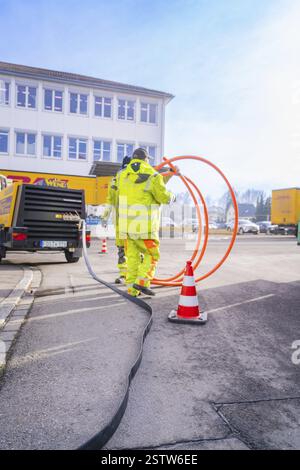 Worker with cable on construction site in work clothes, Wend Glasfasermontage during jetting of conduits for fibre optic cables, Messkirch, district o Stock Photo
