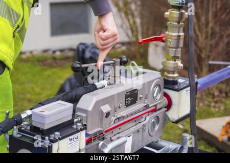 Person points to a mechanical device outdoors, Wend Glasfasermontage during the installation of fibre optic cable ducts, Messkirch, district of Sigmar Stock Photo