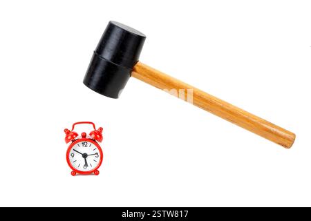 The rubber hammer is about to smash the red tiny alarm clock on white background Stock Photo