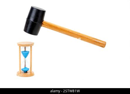 The rubber hammer is about to smash the hourglass clock  on white background. Stock Photo