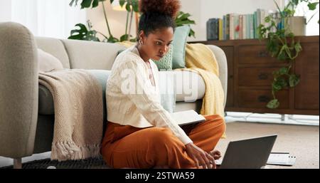 Education, serious and woman with laptop, home and research for assignment in lounge, studying and online. House, knowledge and planning for exam on Stock Photo