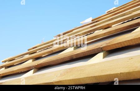 Roofing construction. The roof is ready for roofing, wooden boards and a vapor barrier membrane close up. Stock Photo