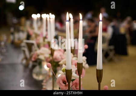 Lighted candles decorating a table during dinner at an outdoor wedding. Spain Stock Photo
