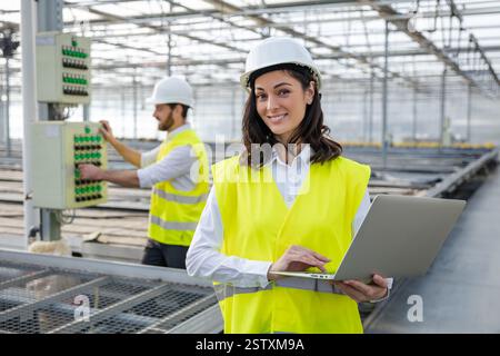 Young female engineer with a laptop checking the parameters at the construction site Stock Photo