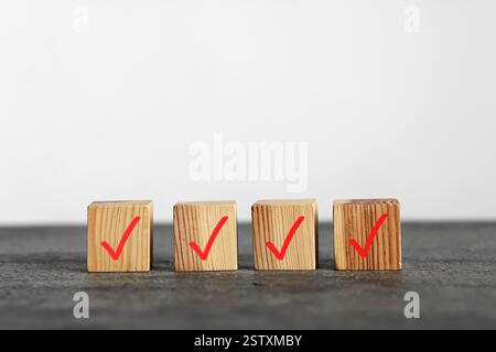 Wooden cubes with check marks on grey table Stock Photo