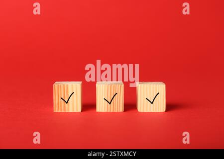 Wooden cubes with check marks on red background Stock Photo