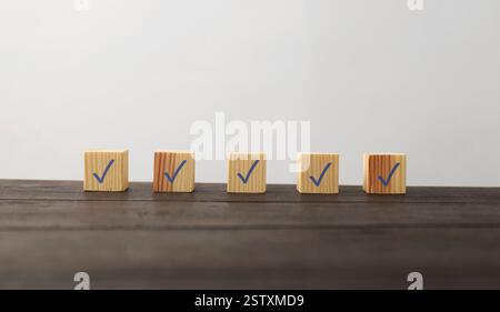 Wooden cubes with check marks on table Stock Photo