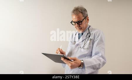 Doctor using a digital tablet to review patient records in a modern hospital. Concept of electronic medical documentation, telemedicine, and innovativ Stock Photo