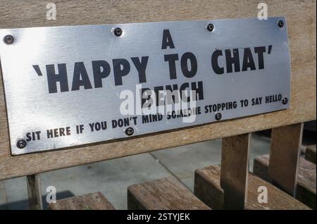 Happy to chat bench in UK city aimed to combat loneliness. Cheerful message on public bench seat Stock Photo
