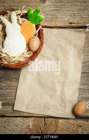 Table top view of buttery sugar cookies and Easter eggs in a nest on the rustic wooden background with blank paper, Mock up for greeting card or cooki Stock Photo