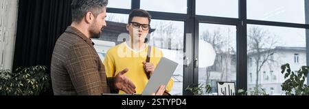 Two coworkers engage in a friendly conversation as they navigate the onboarding process together. Stock Photo