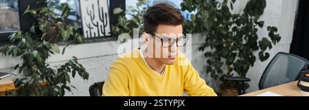 Newcomer finishes onboarding tasks in a bright, plant filled office. Stock Photo