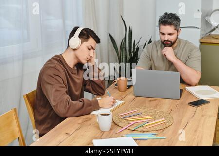 Two brothers engage in a productive study session at home, surrounded by a cozy atmosphere. Stock Photo