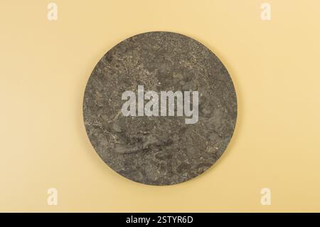 Top view of brown marble plate on yellow background. Food presentation, stone tray. Copy space, flat lay. Stock Photo